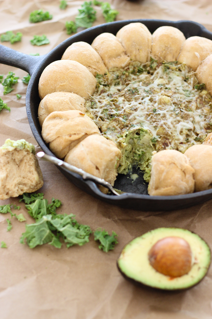 A healthy dip made with avocado, kale, artichokes, and greek yogurt along with homemade whole wheat garlic rolls!